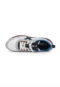 Zapatillas multicolores con una parte superior de malla blanca, acentos de ante gris, rayas azul marino, cordones blancos y una suela de goma roja. Inserciones texturizadas visibles.