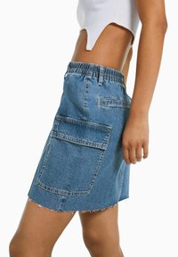 Džínová sukně ve světle modré barvě s elastickým pasem, roztrhaným lemem a dvěma velkými zadními kapsami. Pohodlný A-linii tvar.