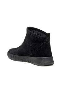 Stivaletti alla caviglia in suede nero con punta tonda, suola in gomma flessibile e linguetta posteriore per facilitare la calzata. Texture liscia complessiva.