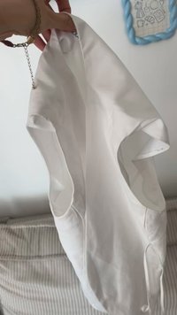 Vit ärmlös topp i slät tyg med svängda ärmhål och rundad halsringning, som visar upp en enkel och ren design.