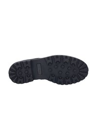 Suela de zapato de goma negra con una superficie texturizada y múltiples patrones de tracción para agarre, incluyendo diseños circulares y en forma de cruz.