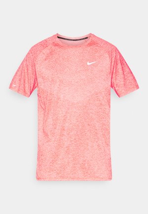 Camiseta de manga corta y cuello redondo en tejido rosado jaspeado con el logo blanco de Nike en el pecho. Presenta un acabado texturizado y mangas raglán.