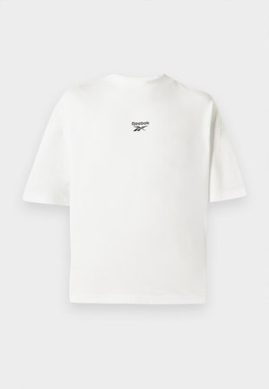 Bela kratka majica s kratkimi rokavi iz bombaža, z majhnim črnim logotipom Reebok na zgornjem delu hrbta, sproščenega kroja in preprostim dizajnom.