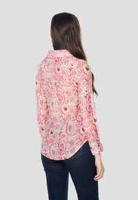 Ružová košeľa s dlhými rukávmi a paisley vzorom, s golierom a gombíkmi, vyrobená z ľahkej látky.
