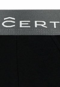 Czarne legginsy z teksturowanym szarym pasem w talii, na którym widnieje słowo "CERT" w białym kolorze, podkreślające elegancki i funkcjonalny design.