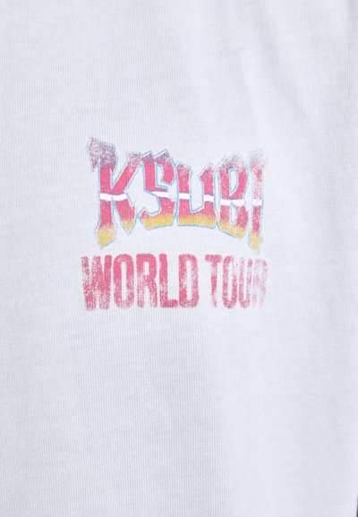 Biela bavlnená tričko s farebnou grafickou potlačou, ktorá znie "Ksubi World Tour" v tučnom, opotrebovanom písmene.