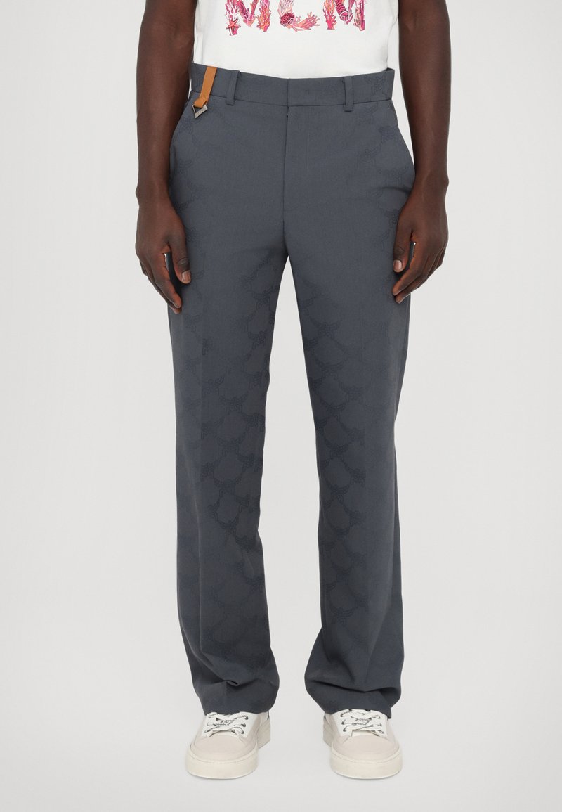 Pantalons grijs ajustés avec un motif subtil, présentant une texture lisse, une taille standard et une fine sangle d'accent brune.
