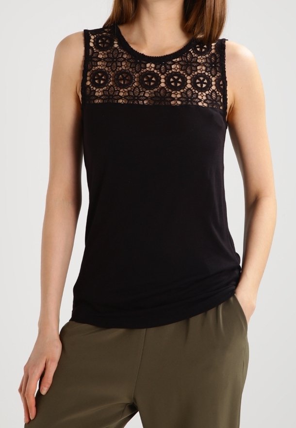 Top sans manches noir avec un empiècement en dentelle à motifs floraux, en tissu doux et avec une coupe décontractée, associé à un pantalon vert olive.
