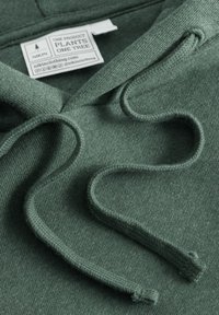 Felpa verde con un tessuto morbido e testurizzato e coulisse. Presenta un'etichetta di marca che indica "Un prodotto pianta un albero."