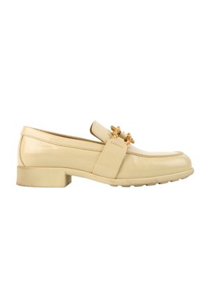 Mocassin en cuir beige avec un petit talon et un détail chaîne dorée sur la tige, présenté en vue latérale sur fond blanc.