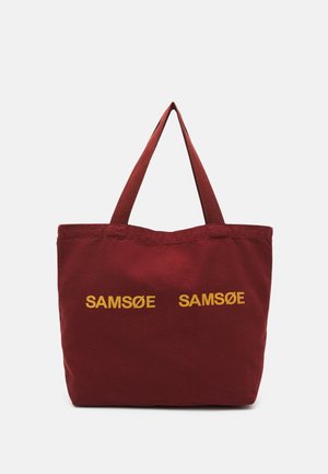 Vinrød mulepose med to håndtag, med gul tekst "SAMSØE SAMSØE" trykt to gange på fronten.