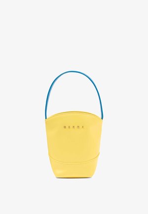 Borsa a secchiello gialla con manico blu e piccole lettere dorate del marchio sul davanti, texture liscia in pelle, design minimalista.