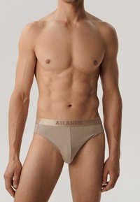 Beżowe męskie slipy wykonane z miękkiego materiału, z gładką teksturą i elastycznym pasem z logo. Klasyczny, dopasowany krój z niskim stanem.