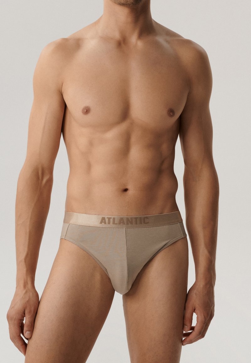 Beżowe męskie slipy wykonane z miękkiego materiału, z gładką teksturą i elastycznym pasem z logo. Klasyczny, dopasowany krój z niskim stanem.