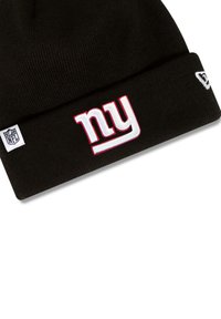 Black knit beanie with "ny" logo in white and red embroidery, featuring NFL tag on the lower side, ribbed texture, and fold-over design.