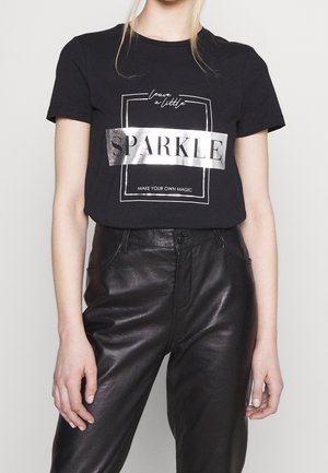 Black cotton t-shirt with a metallic silver "SPARKLE" graphic and text underneath. Paired with black faux leather high-waisted pants.