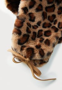 Cachecol de pelúcia falsa com estampa de leopardo, apresentando uma textura macia, um fecho em laço castanho e um rótulo da marca visível com a inscrição "BARTS."
