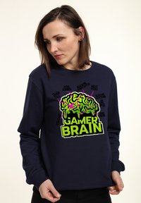 Felpa blu navy con una grafica colorata di un cervello accompagnato dalle parole "GAMER BRAIN", contornato da vivaci accenti verdi e rosa.