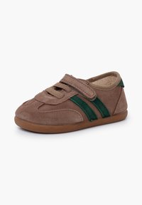 Chaussure en suède brun avec des accents rayés verts, dotée d'une bande Velcro et d'une semelle souple et flexible pour un confort optimal et un enfilage facile.