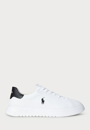 White low-top sneaker with black heel tab and black Polo Ralph Lauren logo on side, featuring white laces and thick rubber sole.