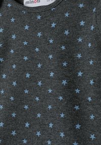 Temno siva tkanina s razpršenimi majhnimi svetlo modrimi zvezdami in okroglim ovratnikom, ki je viden na vrhu.