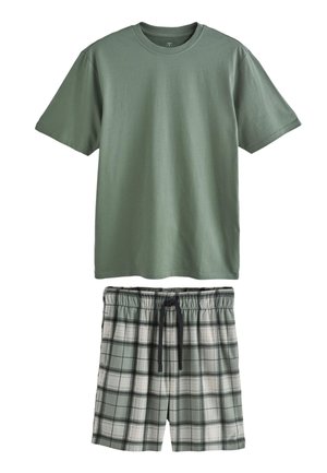 Prosty zielony t-shirt z krótkim rękawem w zestawie z zielonymi, czarnymi i białymi szortami w kratę z czarnym ściągaczem w pasie.