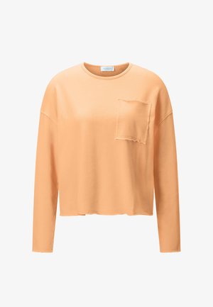 Hanorac crop cu mâneci lungi, portocaliu deschis, cu buzunar pe piept cu margine nefinisată și decolteu rotund.