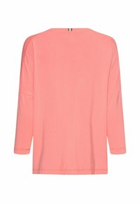 Korallfarvet langærmet bluse lavet af blødt stof. Har rund halsudskæring og en let løs pasform med faldne skuldre og et enkelt design.
