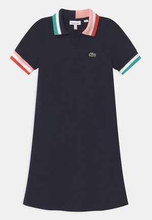 Granatowa sukienka polo z krótkimi rękawami, wielokolorowym paskowanym kołnierzem i mankietami oraz małym zielonym logo krokodyla na piersi.