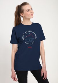 Granatowy bawełniany t-shirt z grafiką przedstawiającą g�óry, słońce i fale. Napis głosi "Durham Mountaineering Od 1981 roku."