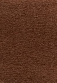 Tessuto di feltro marrone con superficie morbida e testurizzata, che mostra una tonalità uniforme e lievi variazioni di spessore. Adatto per lavori di artigianato e tappezzeria.