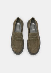 Tumedast rohelisest nahast loafers, millel on ümmargune varvas ja õmmeldud detail üle jala. Must kummist tallaga ja nahast sisetald.