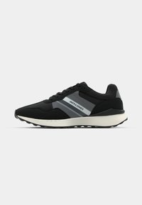 Black athletic sneakers with a textured upper, grey accents, laces, and a lightweight white sole. Features brand logo on the side.