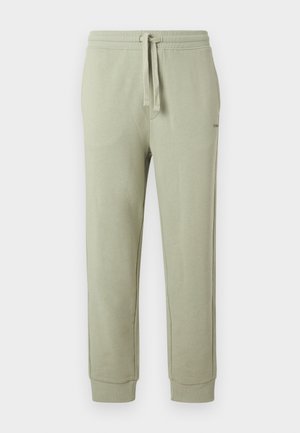 Ανοιχτό πράσινο παντελόνι τζόγκινγκ με ρυθμιζόμενο κορδόνι στη μέση και λάστιχο στους αστραγάλους, κατασκευασμένο από μαλακό ύφασμα, παρουσιάζεται σε απλό φόντο.