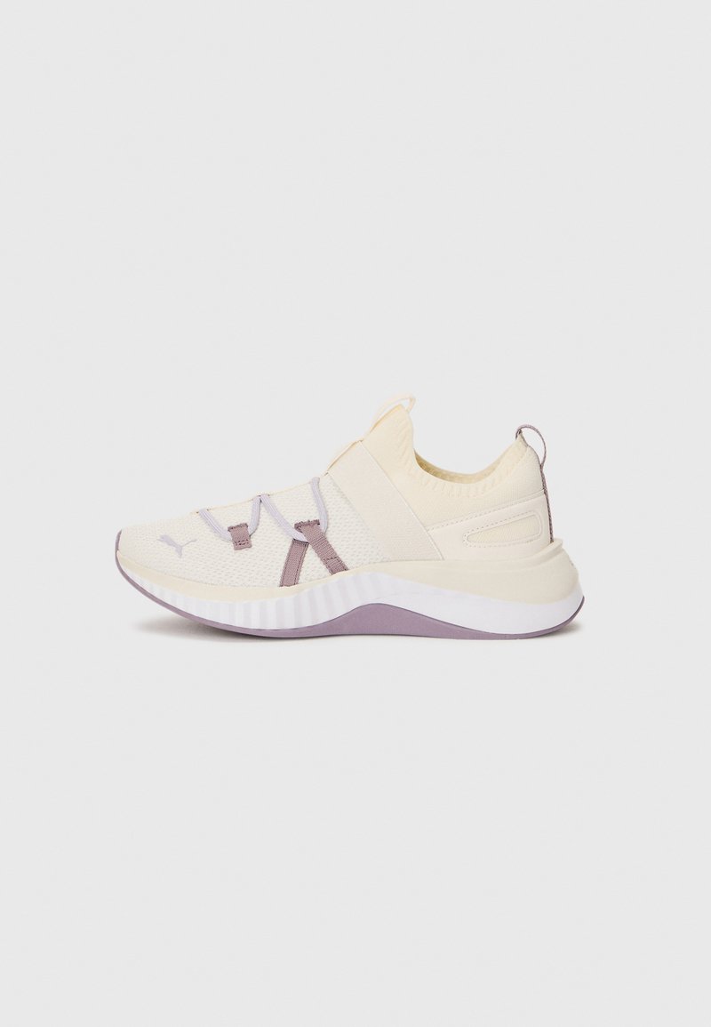 Light cream sneaker with elastic straps and soft textured knit upper. Features a white midsole with lavender accents and rounded heel design.