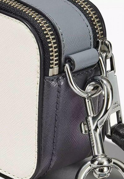 Compact, rectangular bag featuring a grey and white exterior, textured material, metallic zipper, and a chrome hardware clip attachment.