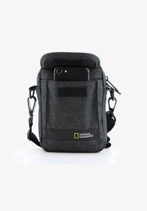 Graue Stoff-Schultertasche mit einer Vordertasche und einem sichtbaren Smartphone. Mit einem National Geographic-Logo und einem Clip zur Befestigung.