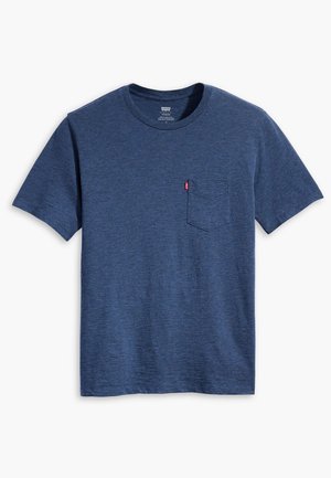 Kék, rövid ujjú, kerek nyakú póló mellzsebbel és a zseben egy kis piros címkével, fehér háttéren kiterítve.