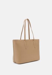 Beige tote-veske laget av strukturelt materiale med to lange håndtak, rektangulær form og jevn tekstur. Ingen synlig maskinvare eller mønstre.
