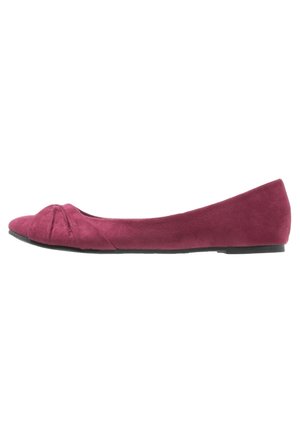 Ballet-flade i bordeaux ruskind med rund tå, gathered stofdetalje foran og en lav sort sål. Elegant og minimalistisk design.