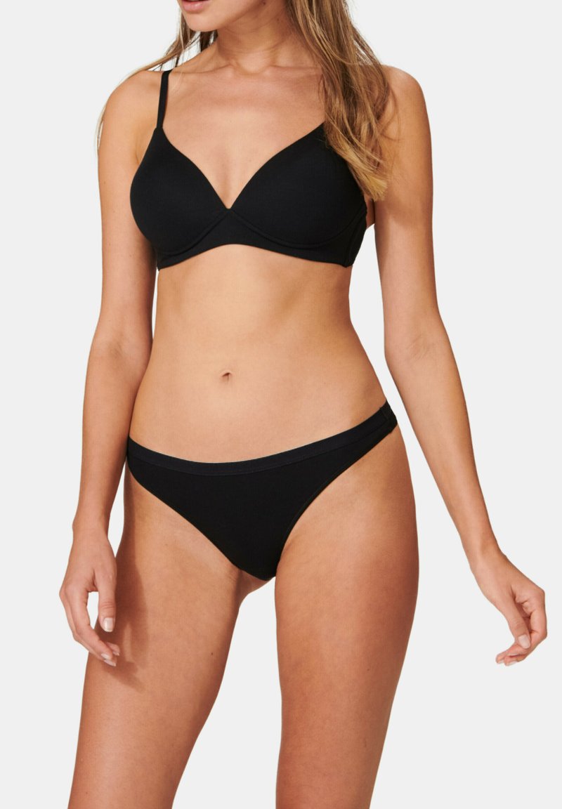 Set di reggiseno e bikini nero realizzato in tessuto morbido. Il reggiseno presenta un design a scollo a V, spalline regolabili e una finitura senza cuciture.