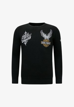 Zwarte trui met lange mouwen. Voorzien van witte en gouden borduursels, waaronder een adelaar en tekstgrafieken. Standaard ronde hals.