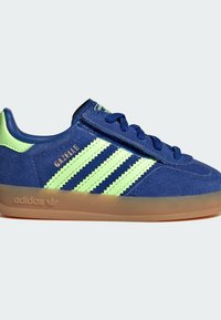 Sneaker Adidas Gazelle in camoscio blu con strisce verde lime, suola in gomma e dettaglio verde abbinato sul tallone.