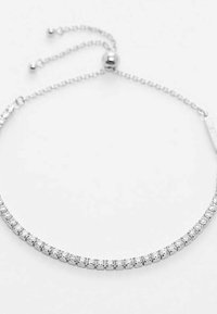 Rhinestone armbånd med en sølvfarvet kæde, der har en række klare, runde sten sat i et lineært design, justerbar lås.