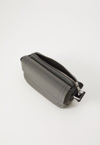 Γκρίζα δερμάτινη τσάντα με ορθογώνιο σχέδιο, διαθέτει κλείσιμο με φερμουάρ και αντιθετική υφή στο καπάκι; περιλαμβάνει μεταλλικά αξεσουάρ.