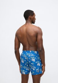 Zilas peldbikses izgatavotas no viegla materiāla, ar krāsainu kuģu un palmu koku rakstu. Elastīga jostasvieta un vaļīgs piegriezums.