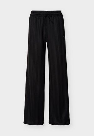 Pantalon large noir avec taille élastique et cordon de serrage, présentant des rayures verticales subtiles et un petit logo latéral.