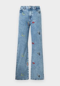Lichtblauwe denim jeans met een wijde pijp, versierd met kleurrijke borduursels van manen, lippen en toekans over de stof.