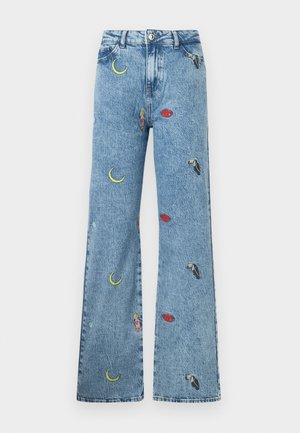 Jean denim bleu clair avec une jambe large, orné de broderies colorées de lunes, de lèvres et de toucans sur tout le tissu.