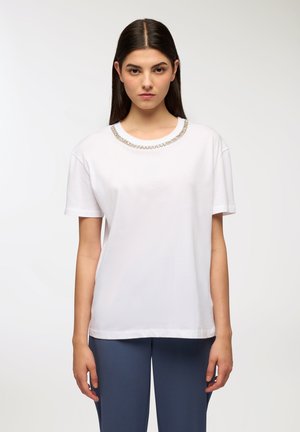 T-shirt bianco a maniche corte con collo rotondo adornato da un dettaglio a catena argentata. Materiale morbido, vestibilità rilassata e orlo dritto.